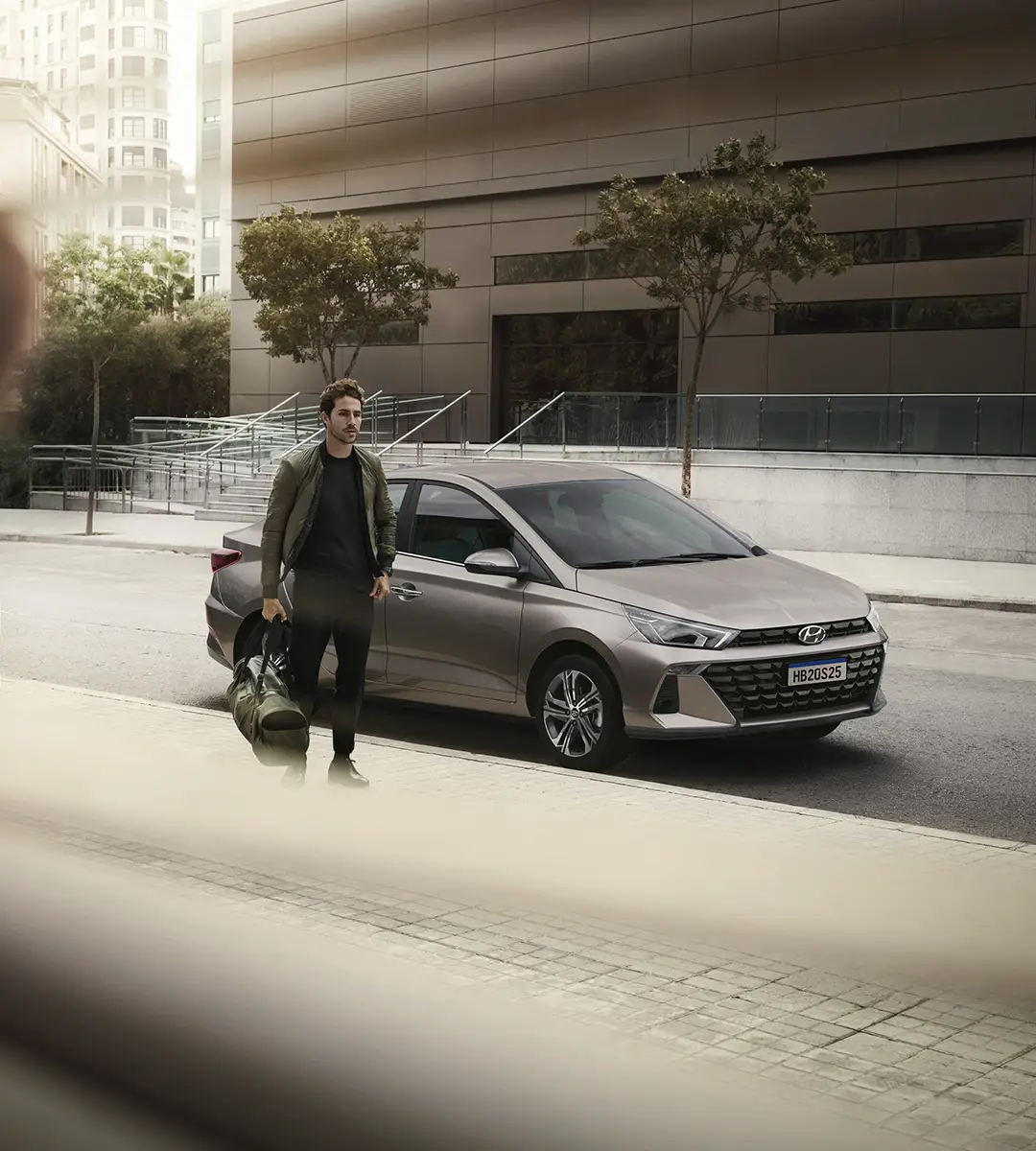 Novo Hyundai HB20S estacionado na rua com um home ao lado