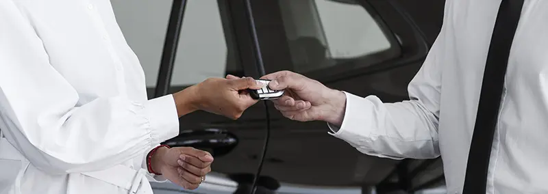 Vendedor entregando a chave do carro após uma negociação na Black Friday.