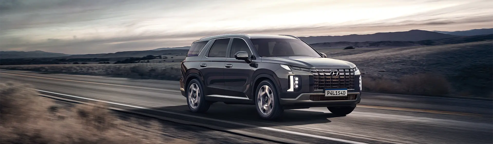 Palisade em alta velocidade em estrada durante o dia com paisagem desértica ao fundo e tempo nublado.