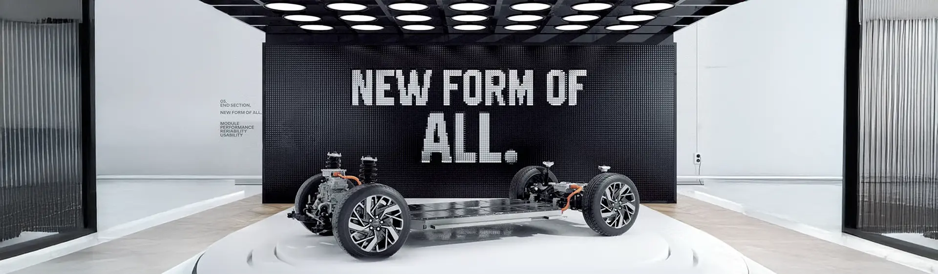 Estrutura da plataforma E-GMP Hyundai em exposição dentro de um salão sobre uma base.